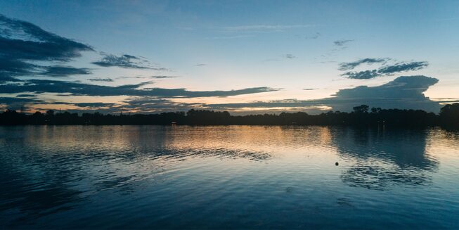 El sol se pone sobre el lago donde Chris Nikic hace su entrenamiento de natación.