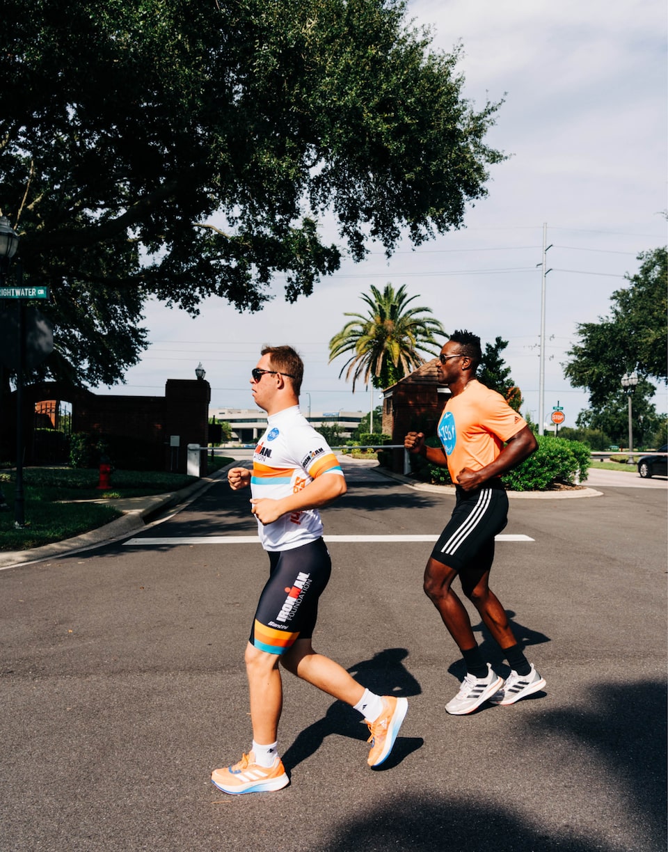 Chris Nikic corre con su compañero de entrenamiento, Marquis Johnson.