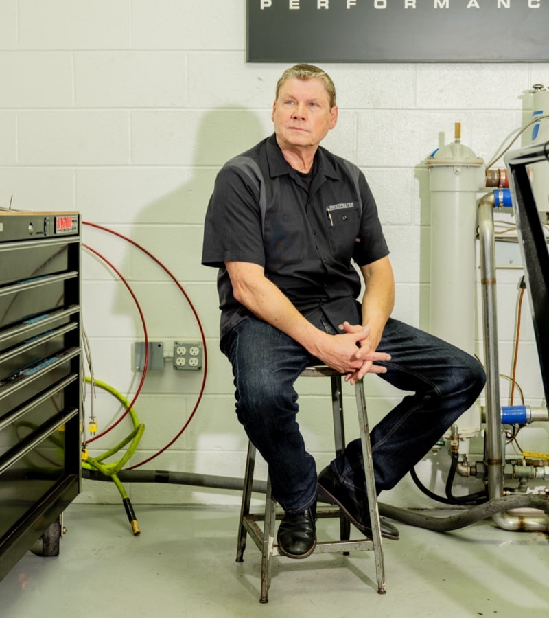 Mark Rapson, COO of Lingenfelter Performance Engineering, sits on a stool in the shop.
