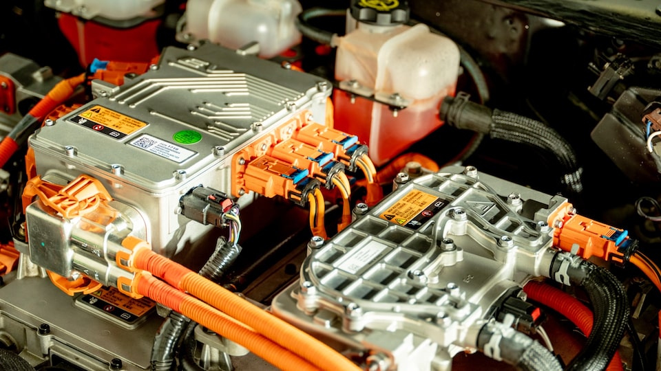 Someone plugs a cord into the charging port of an eCrate electric engine.