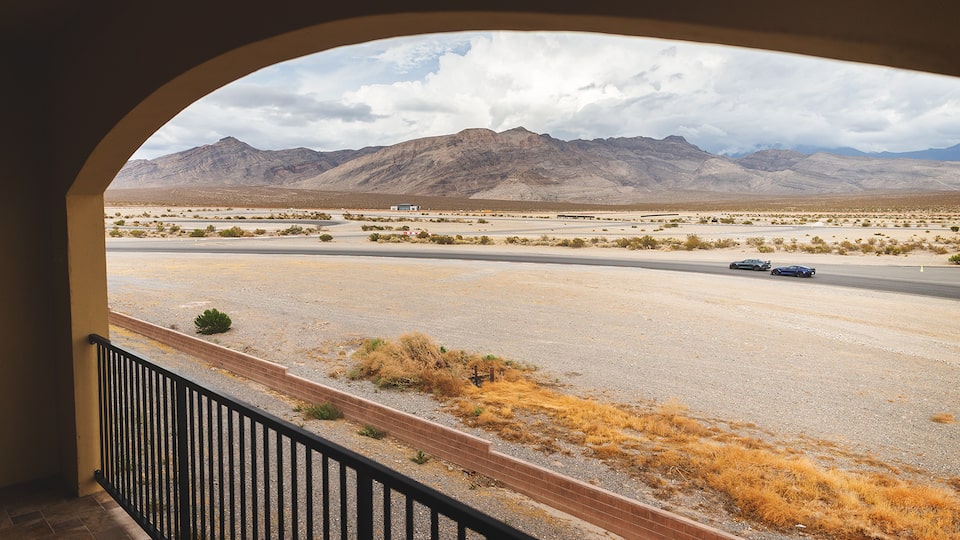 Una Camaro y un Corvette en la pista, vistas desde un balcón de espectadores.