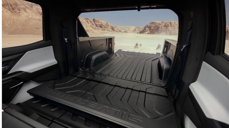 Una vista de la parte trasera de una Silverado EV con la puerta intermedia y la puerta trasera abiertas, que muestra cuánto espacio se crea para la carga.