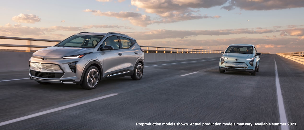 A 2022 Bolt EUV and a 2022 Bolt EV in adjoining lanes on a highway bridge.