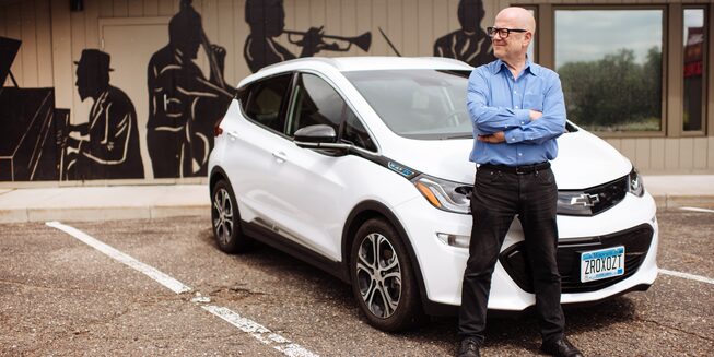 A man stands in front of a Bolt EV.