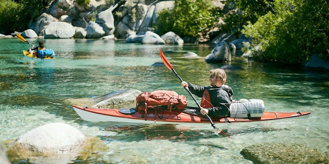 Dos aficionados al kayak reman cerca de la costa del Lago Tahoe.