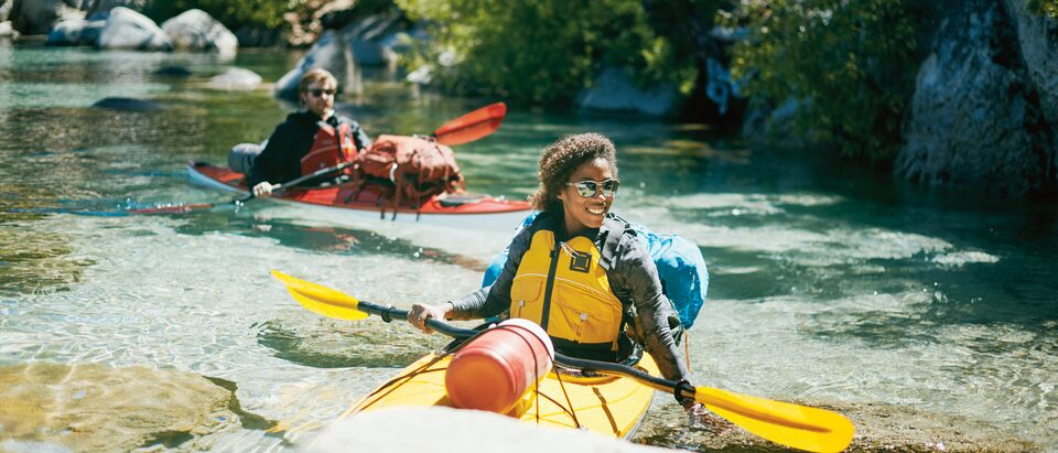 Two kayakers paddling near the shore of Lake Tahoe.