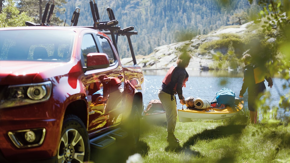 Dos aficionados al kayak descargan uno de la parte de atrás de una Chevy Colorado.