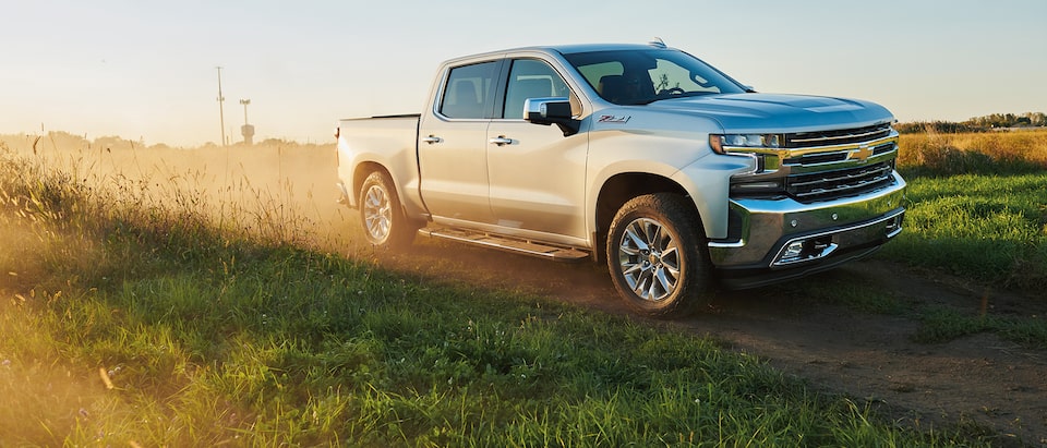 A 2019 Silverado Crew Cab kicks up dust on a dirt road.