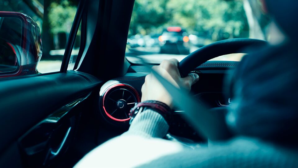 Vista desde el asiento trasero de una Chevy Blazer: un hombre conduce por una calle de Nueva Orleans.
