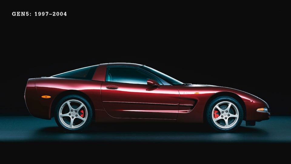 Un Corvette de 5.ª generación (C5, 1997-2004 Borgoña visto de lado con un fondo negro.