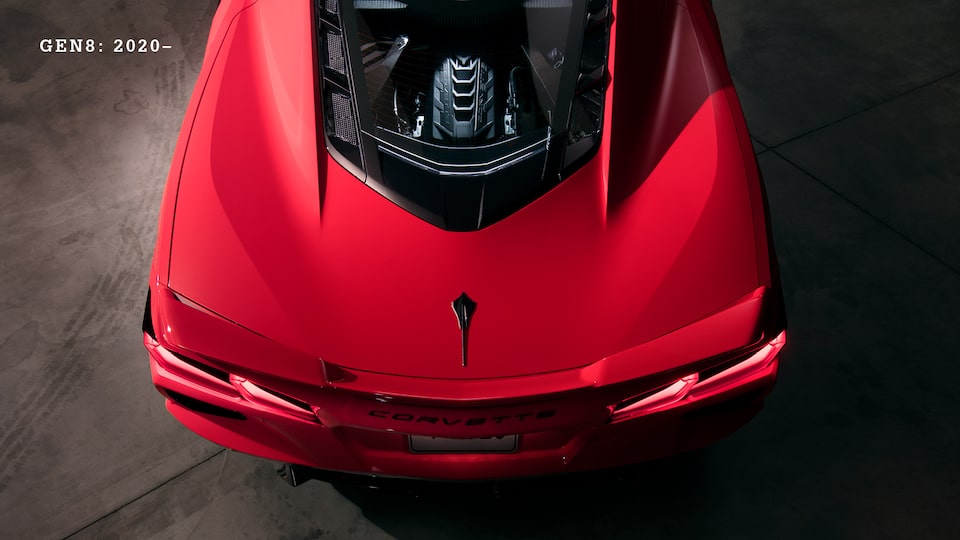 Un Corvette 2020 Rojo nuevo con motor en el centro visto desde arriba, con un plano sobre el compartimiento del motor.