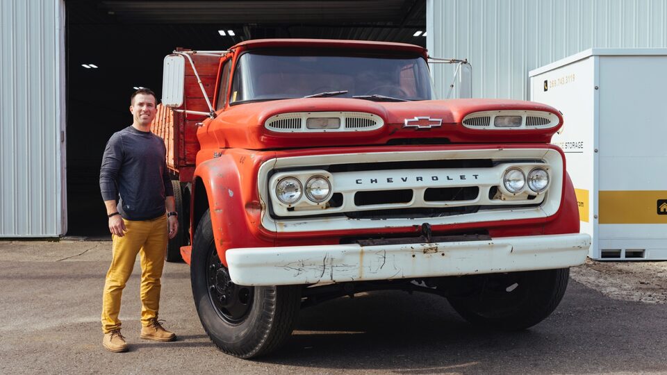 Patrick Carl stands next to his vintage red 1960 Chevrolet C60 Viking pickup outside his storage facility.