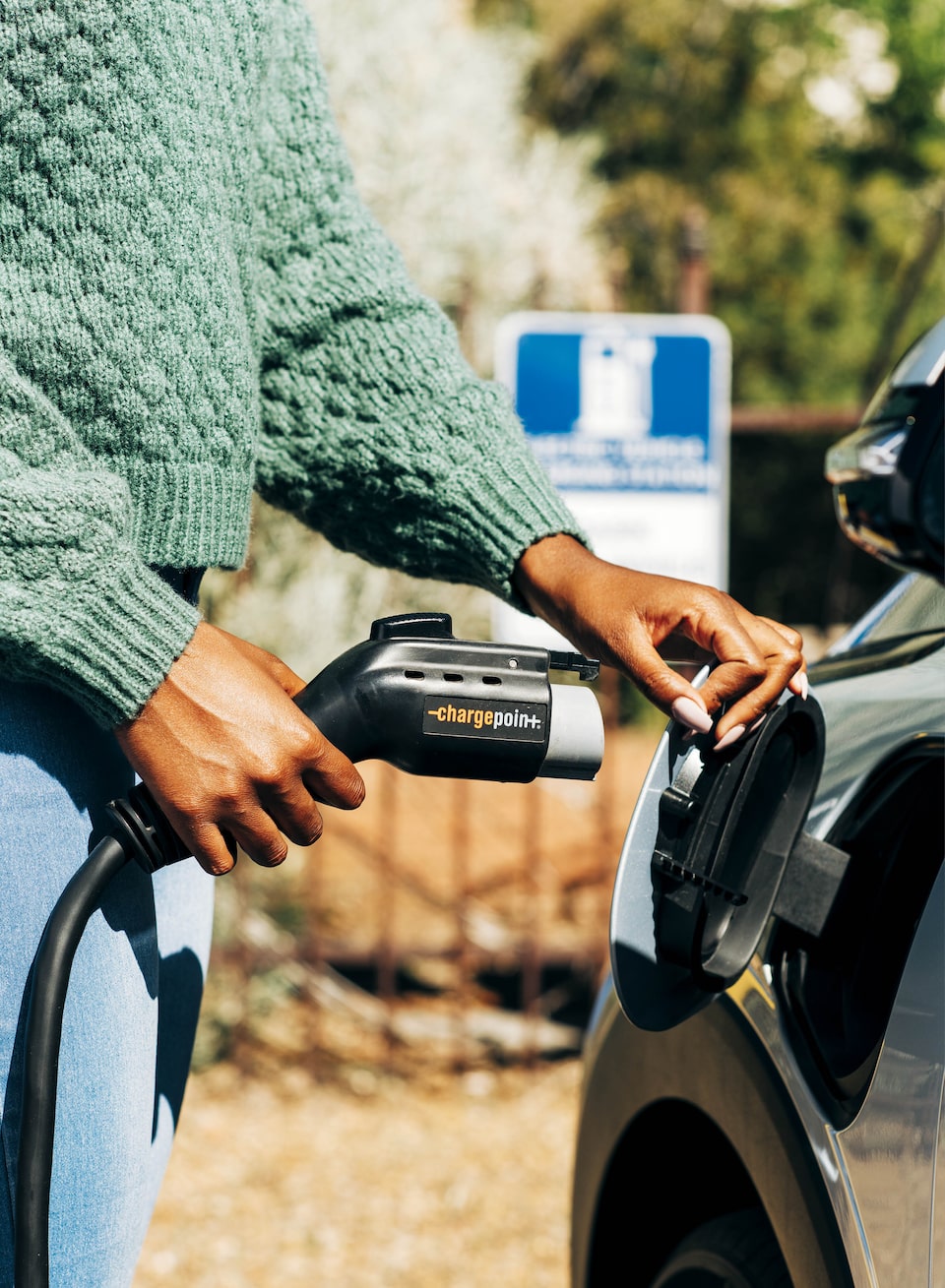 A person plugs a charging cable into a Bolt EUV.