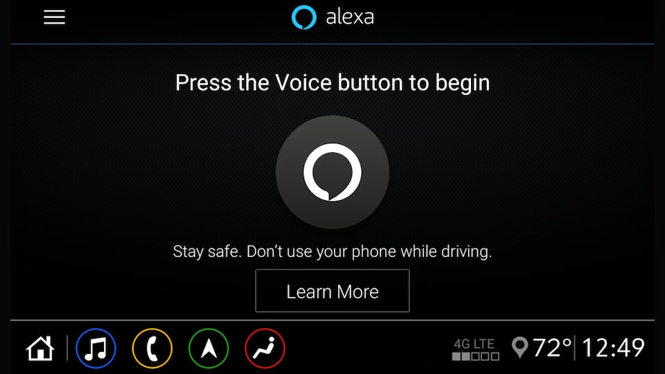 A screenshot of the Alexa Built-in starting screen on the infotainment display in a Chevrolet vehicle. The screenshot shows a button and text that reads: Alexa. Press the voice button to begin. Stay safe. Don’t use your phone while driving. Learn more.