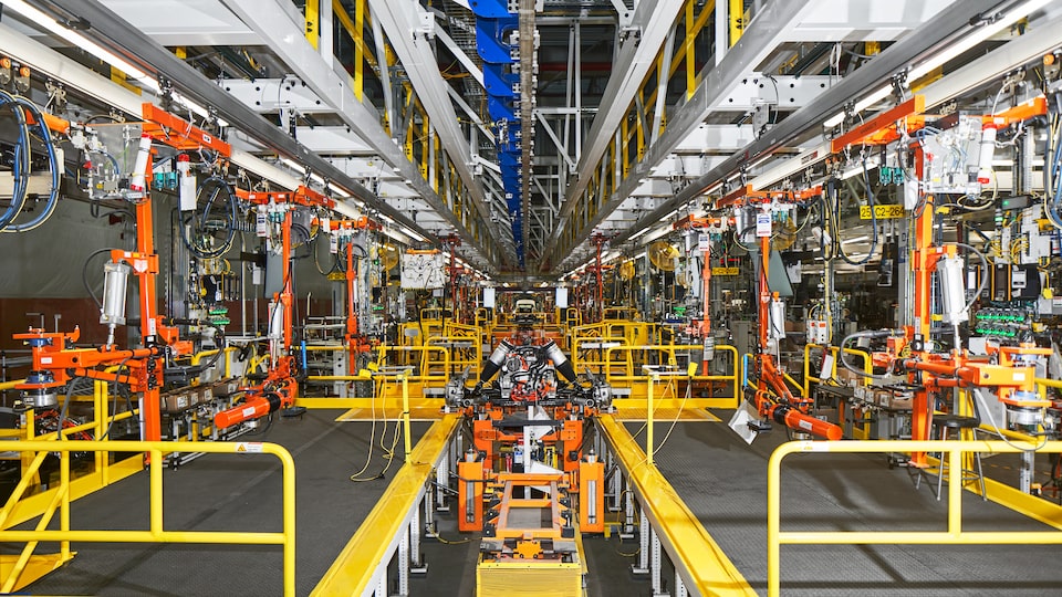 Una vista del interior de Factory Zero, con equipo automatizado que rodea la línea de ensamble y múltiples pantallas que marcan el gran ritmo de trabajo.
