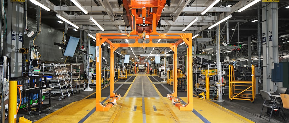 Una vista del interior de Factory Zero, con equipo automatizado que rodea la línea de ensamble y múltiples pantallas que marcan el gran ritmo de trabajo.