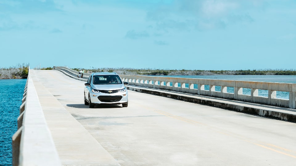 Un Bolt EV en Plata Hielo Metálico que va por una calzada en los Cayos de Florida.