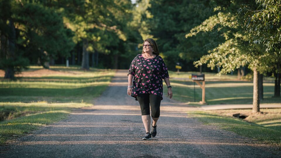 OnStar Member Teresa Moore walks down a rural gravel road.