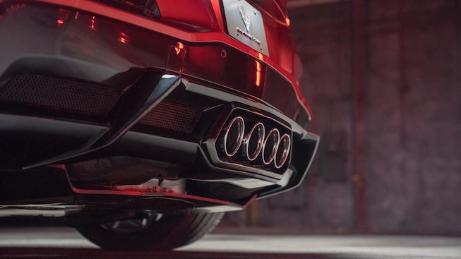A close-up shot of the four center exhaust tips below the rear bumper of a red Corvette Z06.