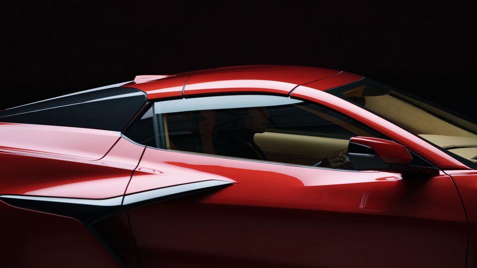 Shot of the passenger side of a red Corvette Z06, cropped in to the hardtop and the door.