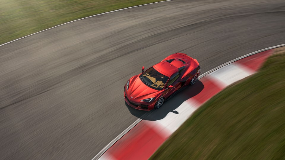 A red Corvette Z06 is seen from above taking an inside turn on a track.
