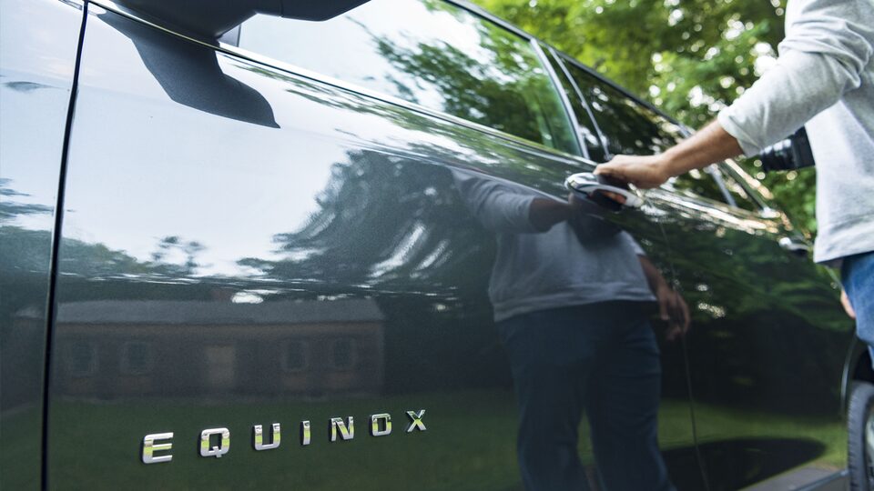 A worm’s-eye-view photo of the Equinox emblem on the driver’s door.