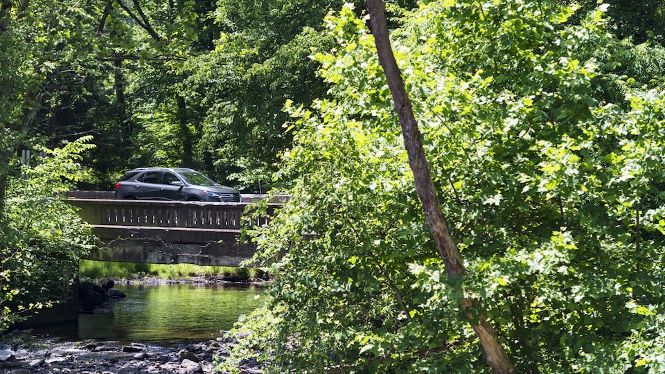 A Chevrolet Equinox crosses a river on a bridge.