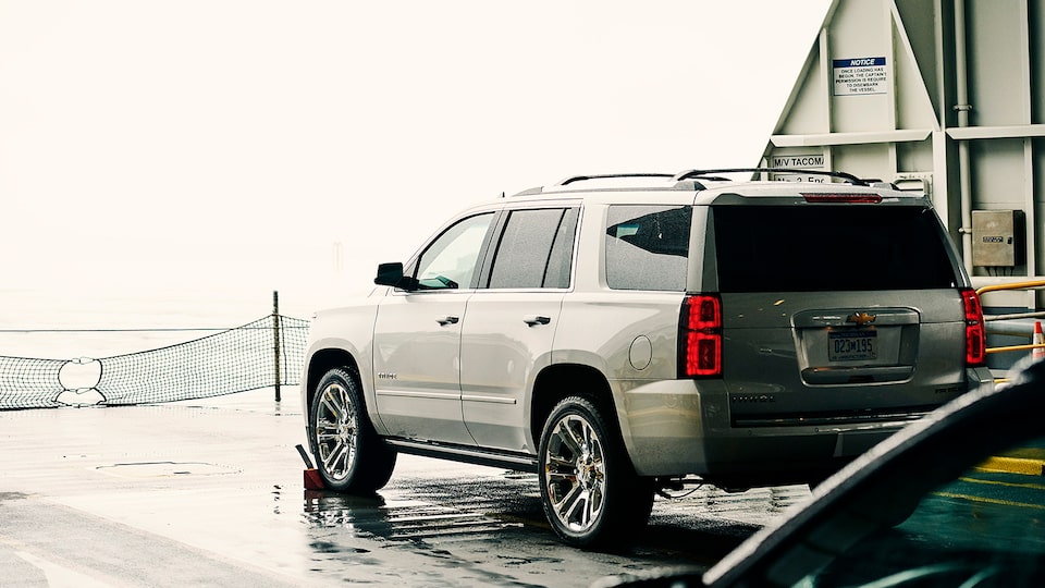 A Chevy Tahoe SUV on the deck of a car ferry, seen from the driver’s side rear.