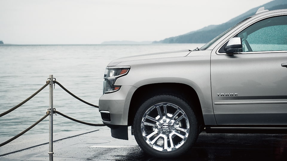 The front driver’s side of a Chevy Tahoe SUV that’s parked on the deck of a car ferry.