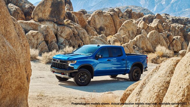Una Silverado ZR2 azul estacionada en un campo de bloques de roca.