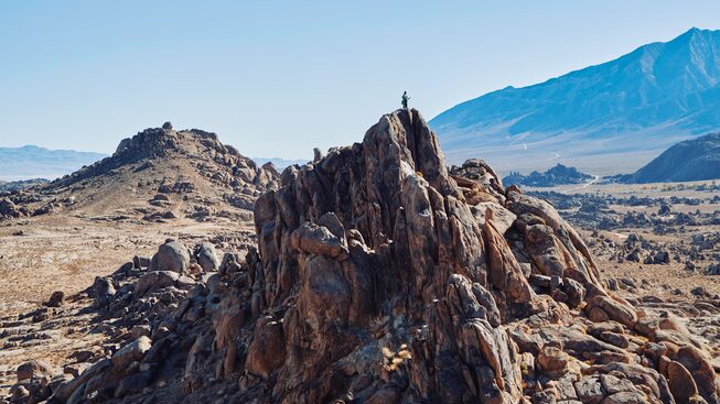 Un saliente de roca con montañas de fondo en Alabama Hills, California.