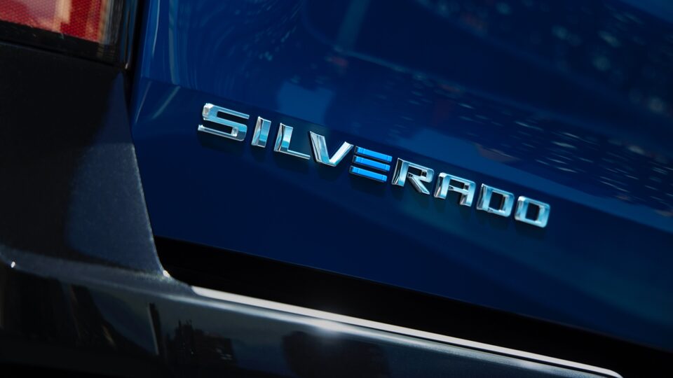Emblema de la Silverado en la puerta trasera de una Silverado EV azul.