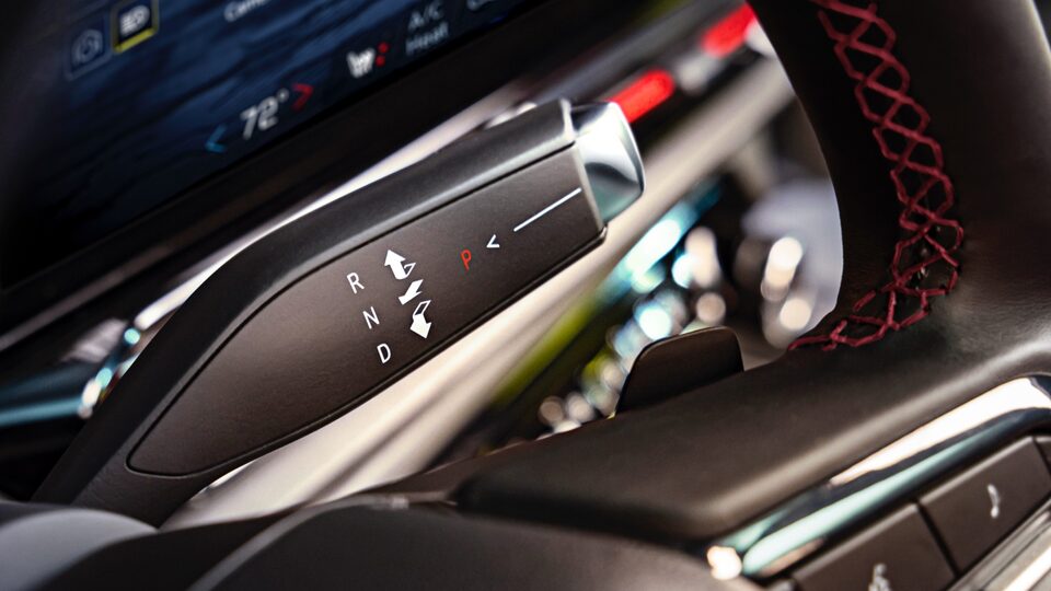 Primer plano de la palanca de cambios que se ubica detrás del volante en una Silverado EV.