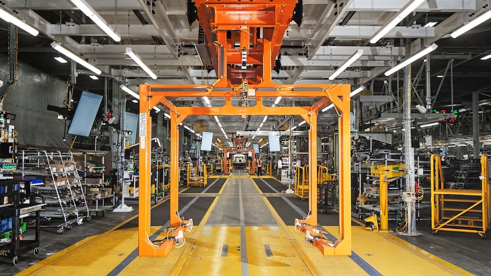 Una vista del interior de Factory Zero, con equipo automatizado que rodea la línea de ensamble y múltiples pantallas que marcan el gran ritmo de trabajo.