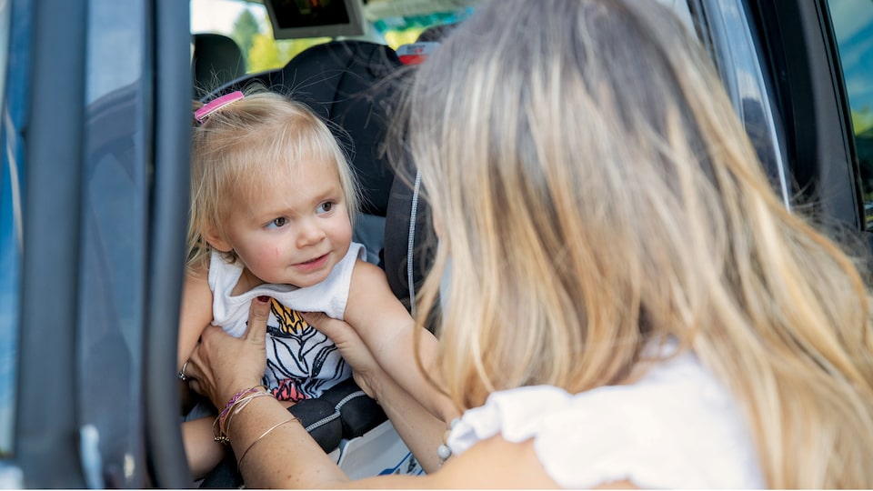 Brittany McLachlan takes her daughter out of her car seat.