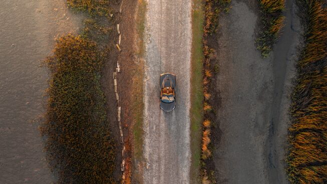 A 2020 Corvette Convertible in Zeus Bronze Metallic is seen in a drone shot from above on a coastal South Carolina road.
