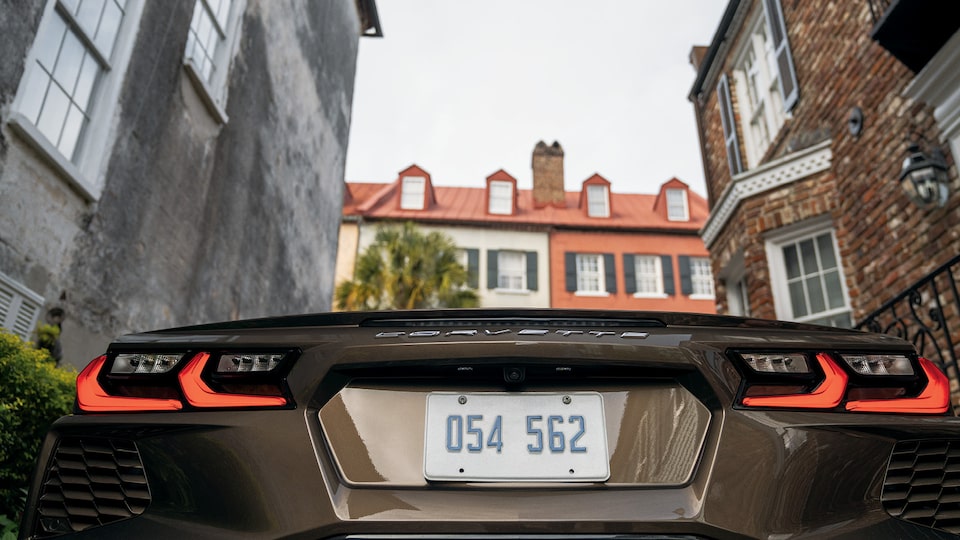 La parte de atrás de un Corvette Convertible 2020 en Bronce Zeus Metálico visto entre los edificios históricos del Barrio Francés de Charleston, Carolina del Sur.
