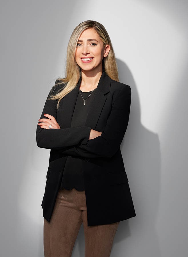 Dalya Aboona, General Motors’ electric vehicle charging and infrastructure lead, stands with her arms folded as she smiles at the camera.