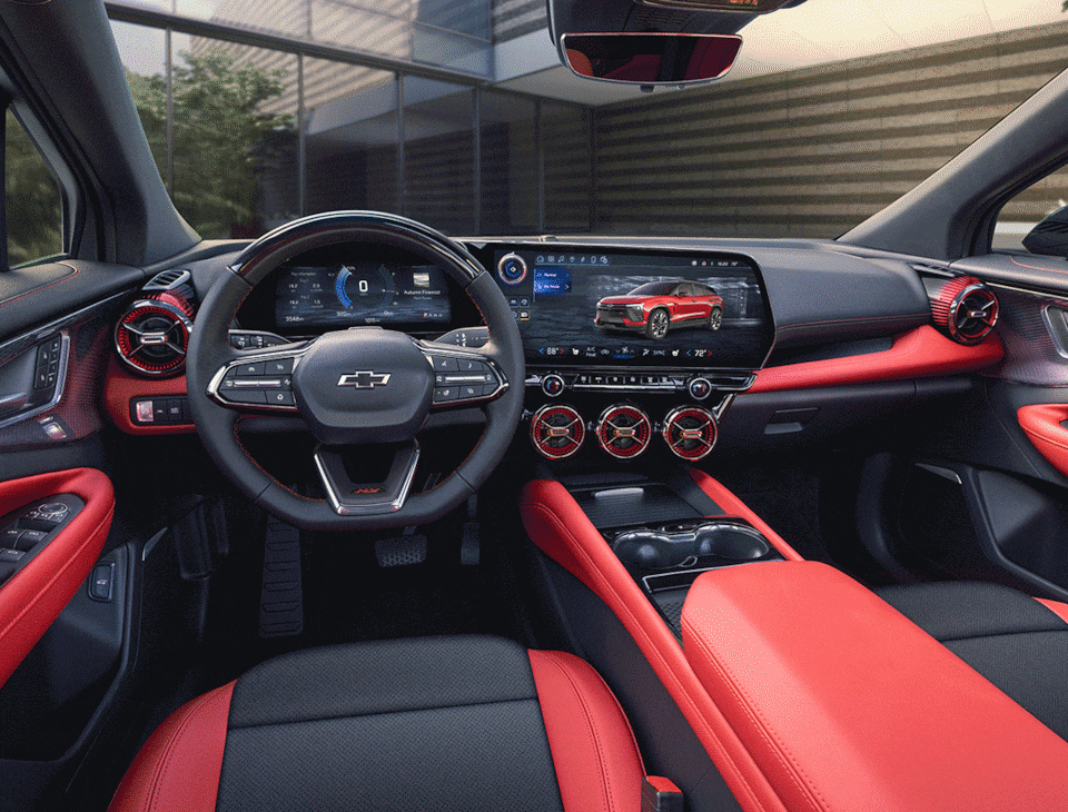 The Blazer EV SS interior viewed from the back seat, showing the front seats, the center console, and the entire dashboard and display screens. Five clickable hotspots are scattered around the image.