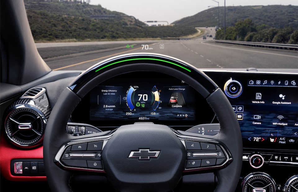 A view out the front windshield of a Blazer EV from the point of view of the driver, showing the steering wheel and the gauge cluster behind it.