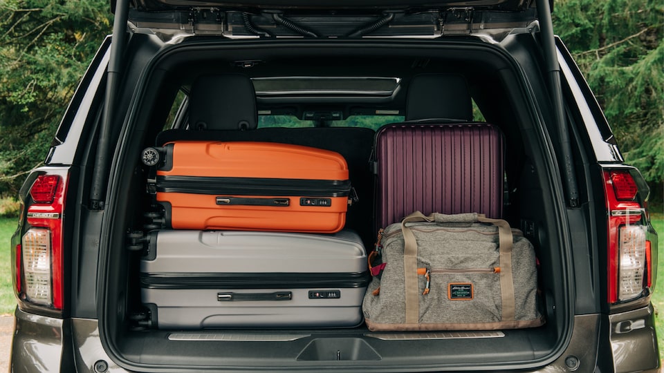 The back of a black 2021 Tahoe packed with suitcases.