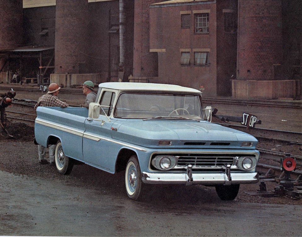 An old photograph from the 1962 C/K Series truck brochure of a light blue pickup from the C/K Series with two men standing behind the bed.