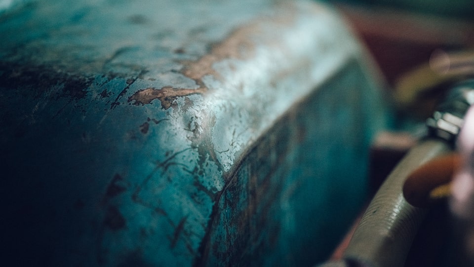 A close-up of a worn and scratched part under the hood of an old Chevy truck.