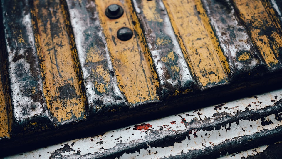 A close-up of the scratched and worn paint in an old Chevy pickup truck bed.
