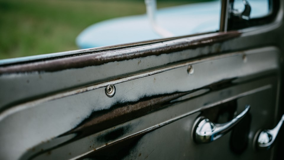 A close-up of the worn area on a door of an old Chevy truck.