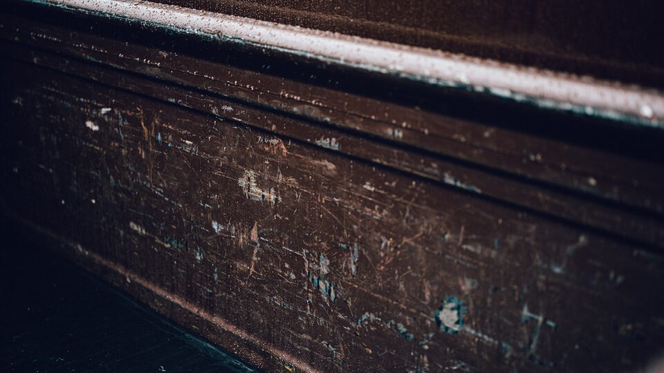 A close-up of a scratched and worn door panel on an old Chevy truck.