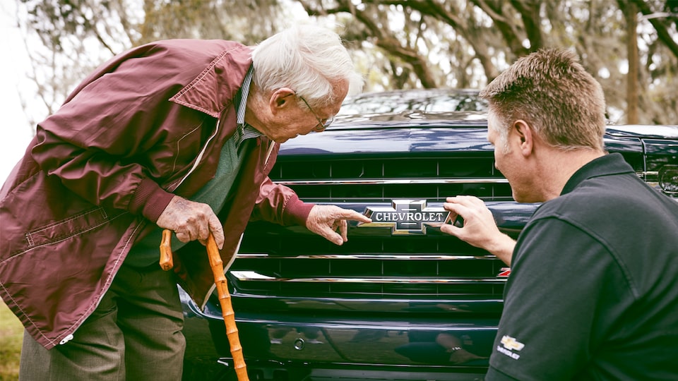 Paul Hitch and Eric Stanczak admire the heritage bowtie on the grille of a Chevy Silverado Centennial Edition.