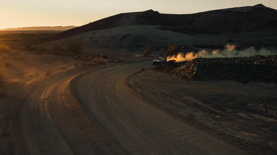 A gif of Chad Hall's racing Colorado ZR2 kicking up dust as he drives at sunset in a remote desert area.