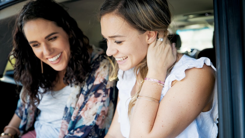 A close-up of Courtney and Brittany McLachlan looking at something off-camera while sitting inside Brittany’s Chevrolet Tahoe.