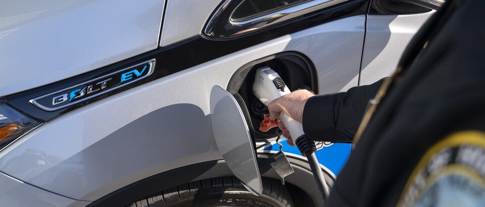 El sargento Richard Hartnett carga el Chevrolet Bolt EV patrulla de su departamento.